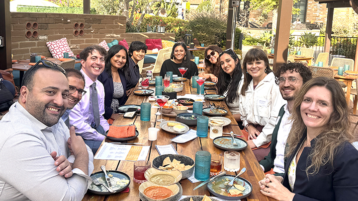 Cohort members, along with the 21st Century India Center team, sit around a table having a meal together outdoors.